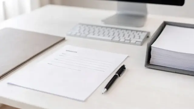 Unterlagen zur Gewerbeanmeldung: Formular, Stift und Ordner zum Thema Gewerbeschein