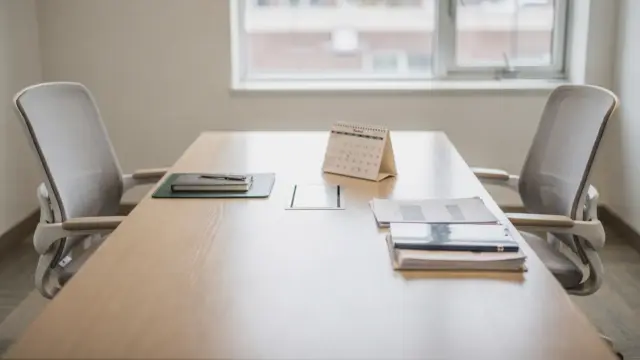 Vorbereiteter Besprechungsraum für ein Mitarbeitergespräch zur Entwicklung mit Notizbuch und Kalender
