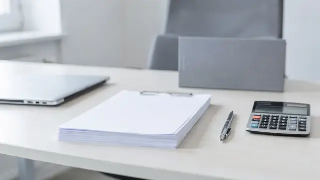 Büro-Setup zur GmbH-Gründung mit Dokumenten, Rechner, Stift und Laptop